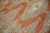Distressed low pile texture on a vintage Persian Veece carpet in rust red and powder blue.