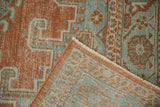 Detail of a distressed Veece rug's corner showing the hand-knotted back and low pile texture.