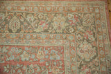 Corner detail of a vintage Sarouk carpet showing floral bouquets in faded red, coffee brown, and powder blue.