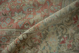 Folded corner of the vintage Sarouk rug showing its distressed low pile and woven foundation.