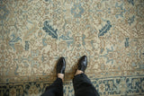 Detailed texture of a distressed Heriz carpet showing low pile and geometric motifs in sand and aqua.