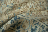Textured low pile of a distressed Heriz rug with visible knot heads in sand and dusty blue.