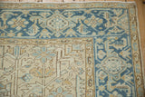 Corner detail of a distressed Heriz carpet's Turtle Samovar and boteh borders in blue, ivory, and sand.
