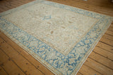 Angled view of a distressed Heriz carpet with a geometric Turtle Samovar border in aqua blue.