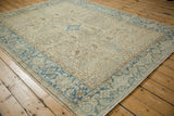 Corner view of a vintage Heriz carpet showing the dusty aqua blue geometric border.