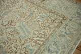 Close-up of distressed Mehrivan carpet's geometric floral field with dusty cream, sea foam, and even wear.