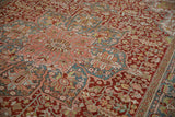 Angled view showing the blush and teal starburst medallion on the distressed Ahar carpet.