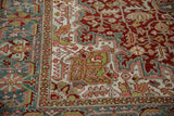 A vintage Ahar carpet's corner showing intricate palmettes in red, dusty teal, and ivory.