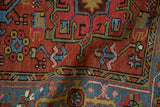 Detail of vintage Karaja rug with brick red field, blue geometric motifs, and Samovar border.