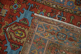Folded vintage Karaja rug showing brick red and blue geometric pile, white fringe, and reverse weave.