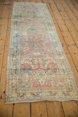 Distressed vintage Sarouk runner, ruby red floral sprays and teal arabesque border.