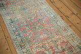 Vintage Distressed Sarouk runner's side edge, featuring intact selvage and faded ruby red traditional floral motifs.