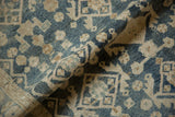 Faded dusty navy blue and beige floral motifs on the textured pile of a distressed Hamadan rug.
