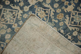 Corner of distressed Hamadan rug displaying foundation, selvage, and faded floral pattern.
