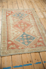 Full angled view of a distressed vintage Shiraz rug showcasing its geometric triple medallion design.