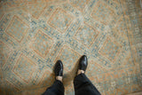 Distressed vintage Afshar rug with allover stepped medallions in pale blue, orange, and ivory hues.