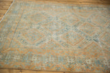 Distressed Afshar rug detail, worn pile with pale orange and sky blue geometric medallions.