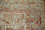 Corner detail of a distressed Heriz rug featuring the Samovar Turtle border motif.
