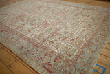 Angled view of a vintage Heriz showing its powder blue border and low-pile distressed texture.