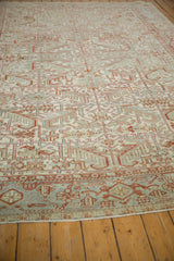 Angled view emphasizing the repeating Samovar Turtle border of a distressed vintage Heriz carpet.