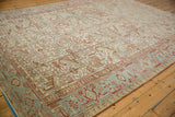 A perspective view of a distressed Heriz carpet showing its even wear and muted pomegranate red and powder blue tones.