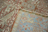 Corner of a vintage Heriz carpet folded to show its hand-knotted back and low pile.