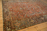 Corner view of a distressed Persian Heriz carpet showing the intricate Turtle Samovar design border.