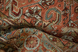 Close-up of serrated leaf and palmette motifs on a softly worn hand-knotted Heriz carpet.