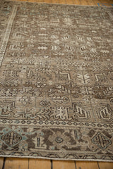 Low angle view of the distressed Mehrivan rug's worn texture and geometric Turtle Samovar border.