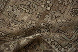 Close-up of a distressed Persian rug's low pile, showing textured wear and geometric motifs.