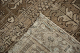 Corner of a distressed Mehrivan carpet folded to show its hand-knotted foundation and pile.