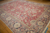 Textured corner of distressed Sparta carpet with raspberry red, navy palmette border.