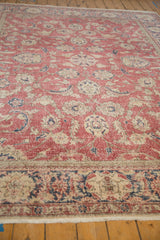 Distressed raspberry red field, faded navy palmettes, scrolled vines of a vintage Sparta rug.