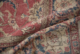 Distressed vintage Sparta carpet pile, showing raspberry red, navy floral vines, and worn texture.
