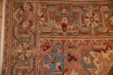 Corner detail of a vintage Heriz carpet showing the floral pomegranate border and evenly worn pile.
