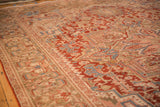 Angled view of the distressed Heriz carpet's low pile and geometric floral motifs.