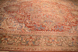Angled view highlighting the even wear and geometric pattern of a distressed Heriz carpet.