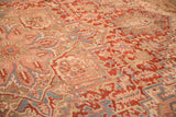 Angled view revealing the even wear and low pile of a distressed hand-knotted Heriz carpet.