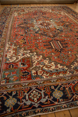 Geometric Herati floral vine motifs in navy blue on a vintage Heriz carpet border.