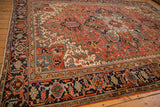 Close-up of Heriz carpet's navy border with Turtle Samovar, Herati, and red, blue motifs.