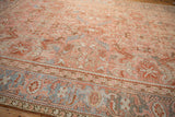 Stylized Herati motifs in the slate blue border of a vintage Heriz carpet with a dusty blush field.