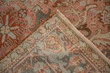 Corner detail of a vintage Heriz rug, folded to display its hand-knotted foundation.