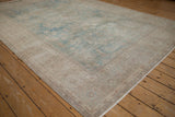 The distressed Tabriz carpet's low-pile texture and time-softened powder blue floral motifs.