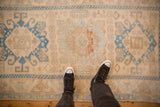 Overhead view of a distressed Malayer rug showing its worn texture and blue geometric medallion.