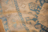 The even, time-softened pile of a distressed Malayer rug showing dusty blue geometric designs.