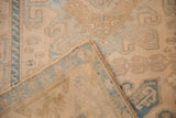 Corner of a distressed Malayer rug showing the low-pile texture and hand-knotted foundation.