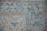 Distressed vintage Mehrivan carpet's geometric pile, showing abrashes in dusty blue and ivory.