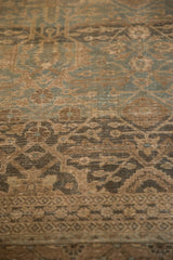 Distressed antique Tabriz rug, showing faded ocean blue-green floral guls and patterned border.