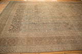Aged Tabriz carpet detail: distressed pile, lattice design, and dusty blue-green hues.