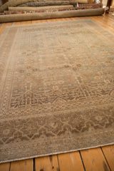 Section of an antique Tabriz rug, revealing faded floral guls and worn geometric border.